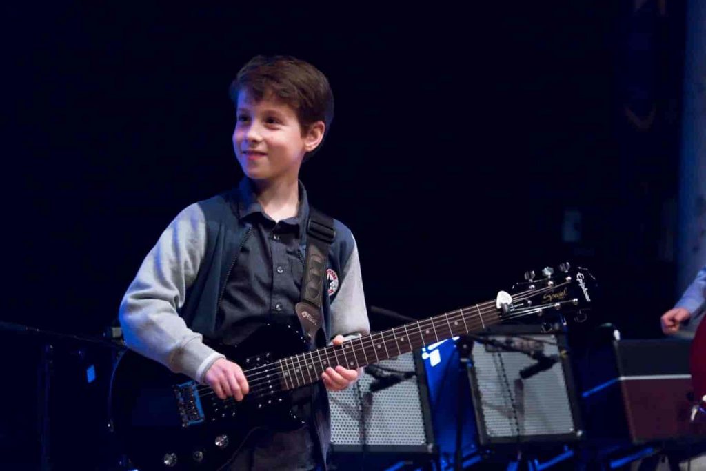 boy playing guitar on stage